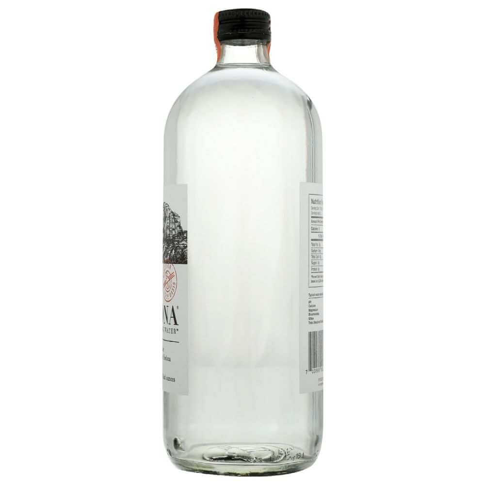 Clear glass bottle of natural mineral water with black cap and visible nutrition label