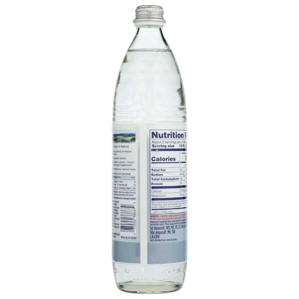 Glass bottle of mineral water with visible nutrition facts label, clear beverage