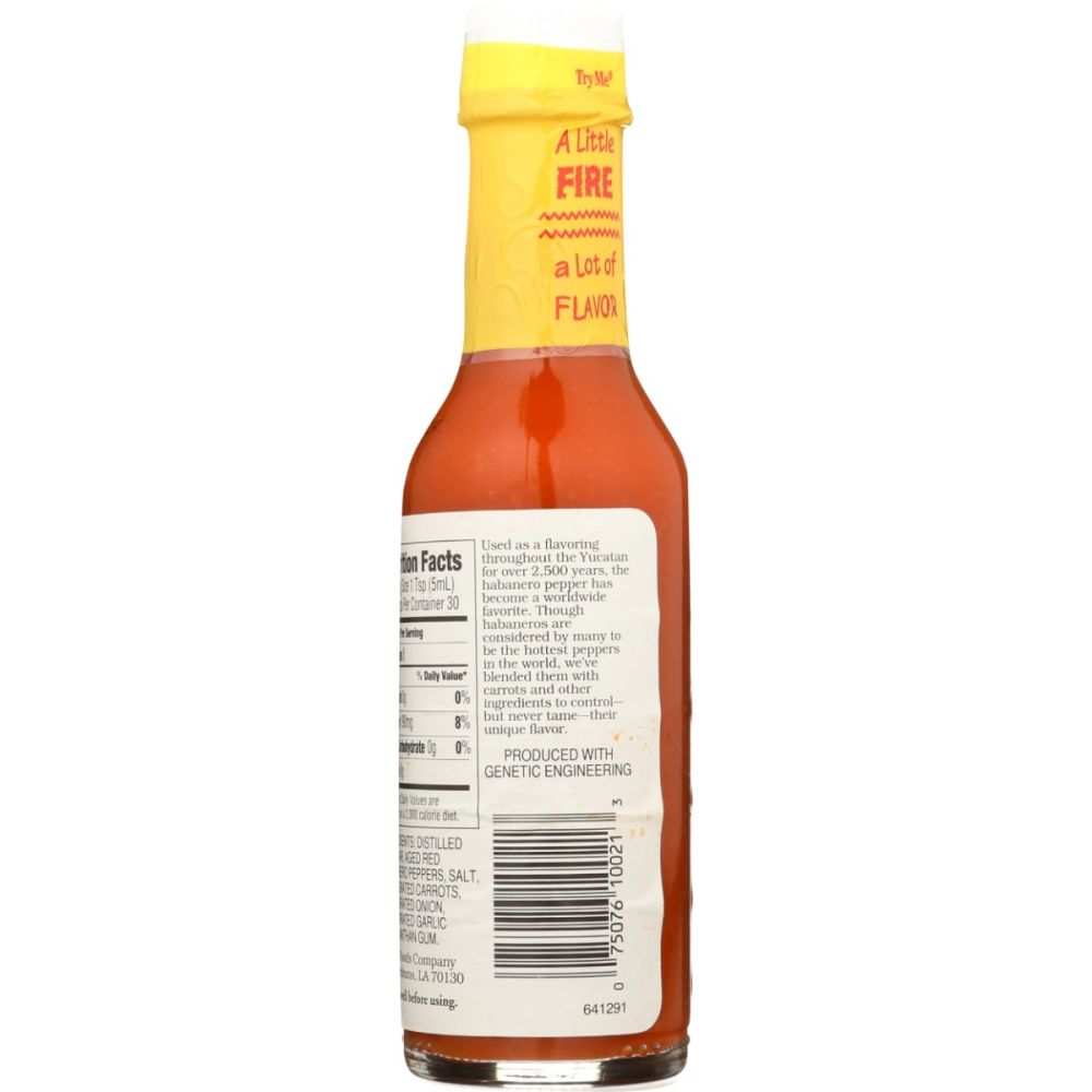 Bottle of Yucatan Sunshine Habanero Sauce with carrots and onions ingredients displayed