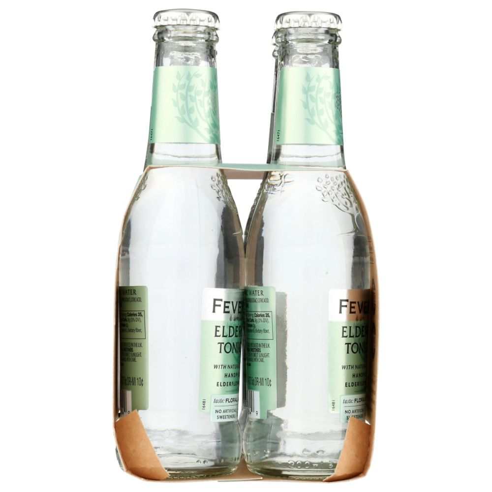 Four glass bottles of elderflower tonic water in cardboard carrier, wellness beverage