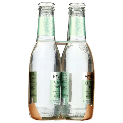Four glass bottles of elderflower tonic water in cardboard carrier, wellness beverage